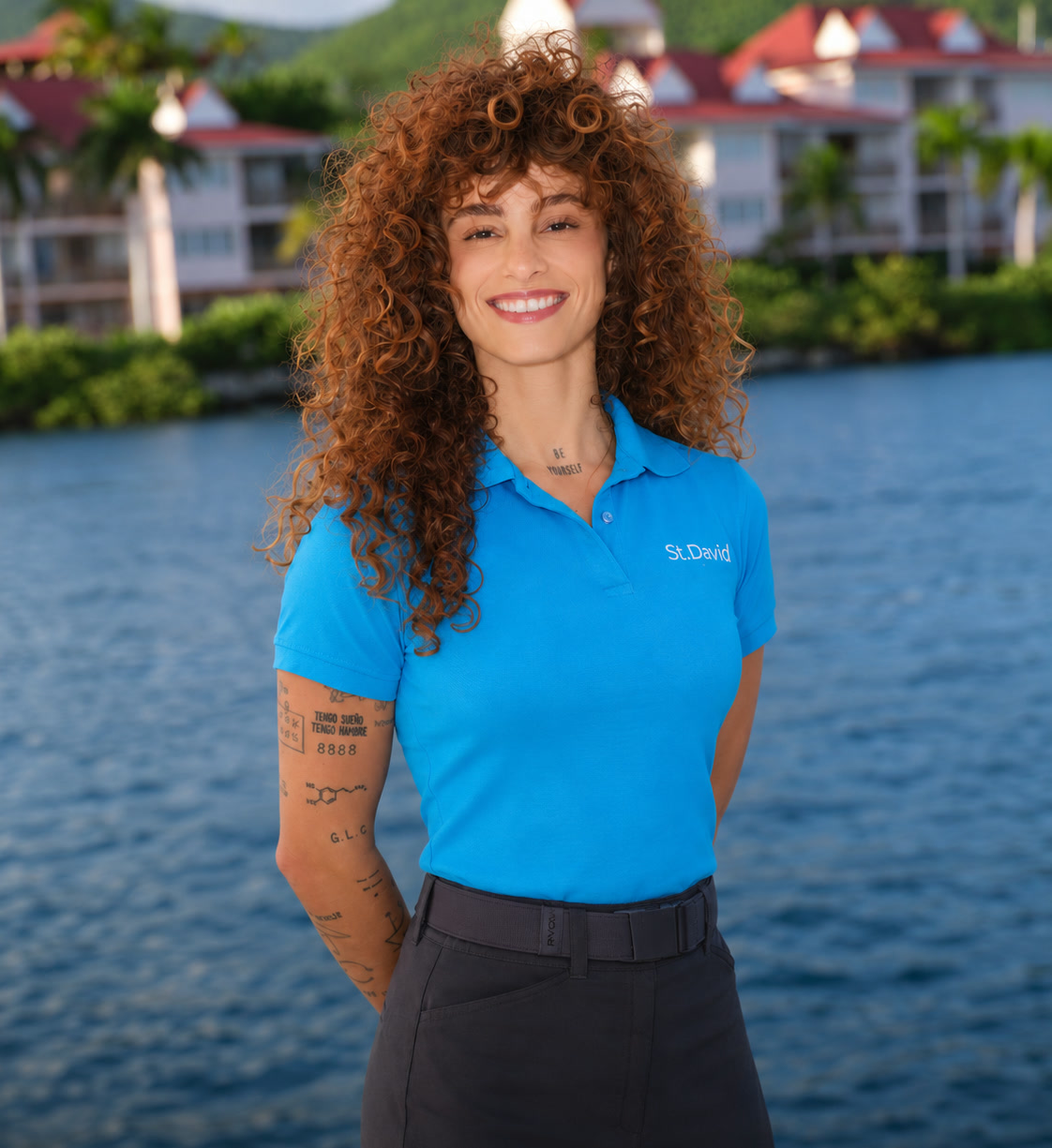 Bárbara Kulaif sorrindo, com o uniforme do Yacht St. David, na frente do mar