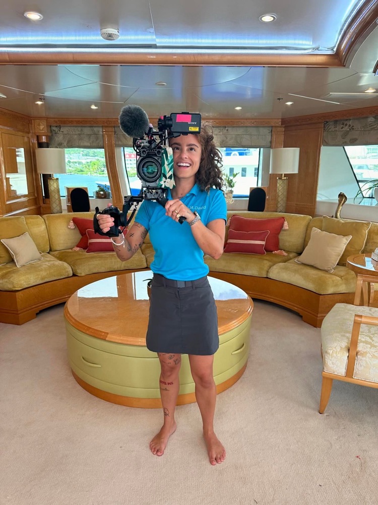 Bárbara segurando uma câmera de filmagem no salão do Yacht do Below Deck