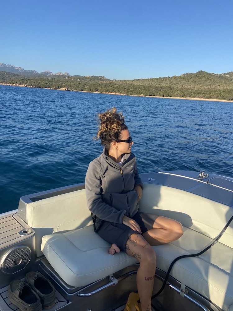 Bárbara sentada no tender de um Yacht no mar da Itália